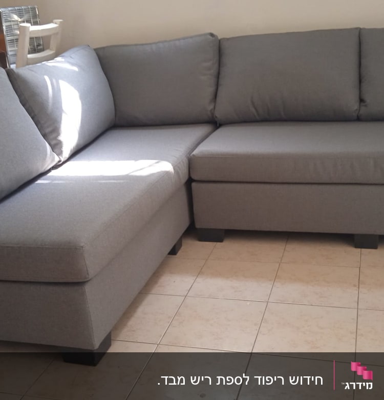 ספה אפורה עם ריפוד מרופד בפינת החדר